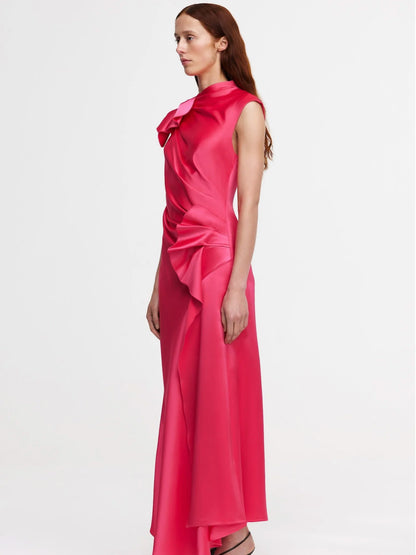 Woman wearing a pink satin dress with a bow detail on a white background